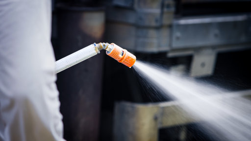 Spraying disinfectant on the floor and surfaces in a livestock barn for farm biosecurity